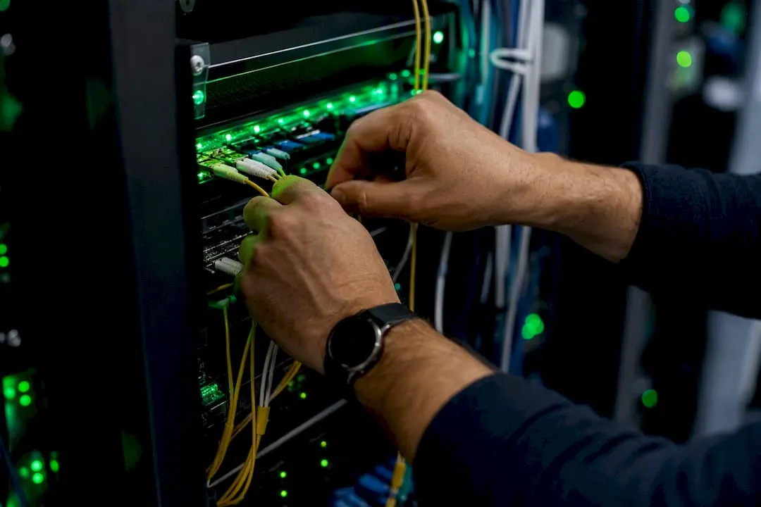 Manos trabajando con cables de una red de telecomunicaciones